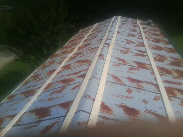 Rusted metal roof panels with new wood purlins before replacement — Storm Damage Roof Repair in Purchase by Roofing Brothers