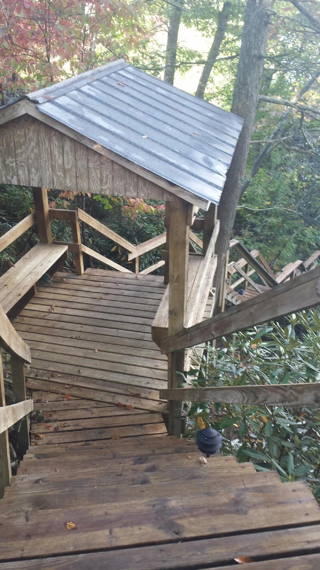 Metal roofed shelter over wooden steps on a wooded walkway — Skylight Repair & Installation work by our crew in Purchase