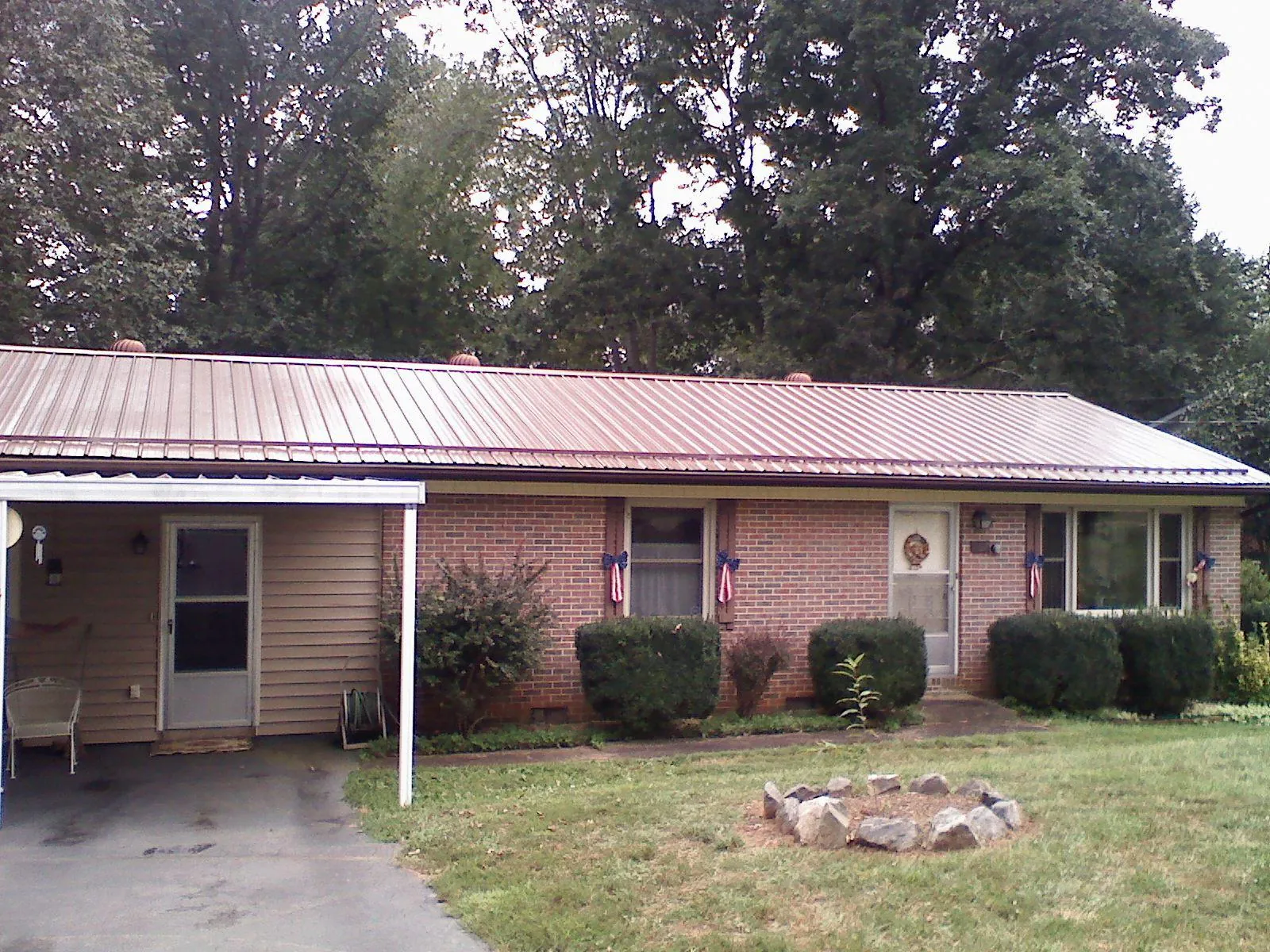 Bronze metal roof and carport on a brick ranch home — Roof Repair work by our crew in Purchase